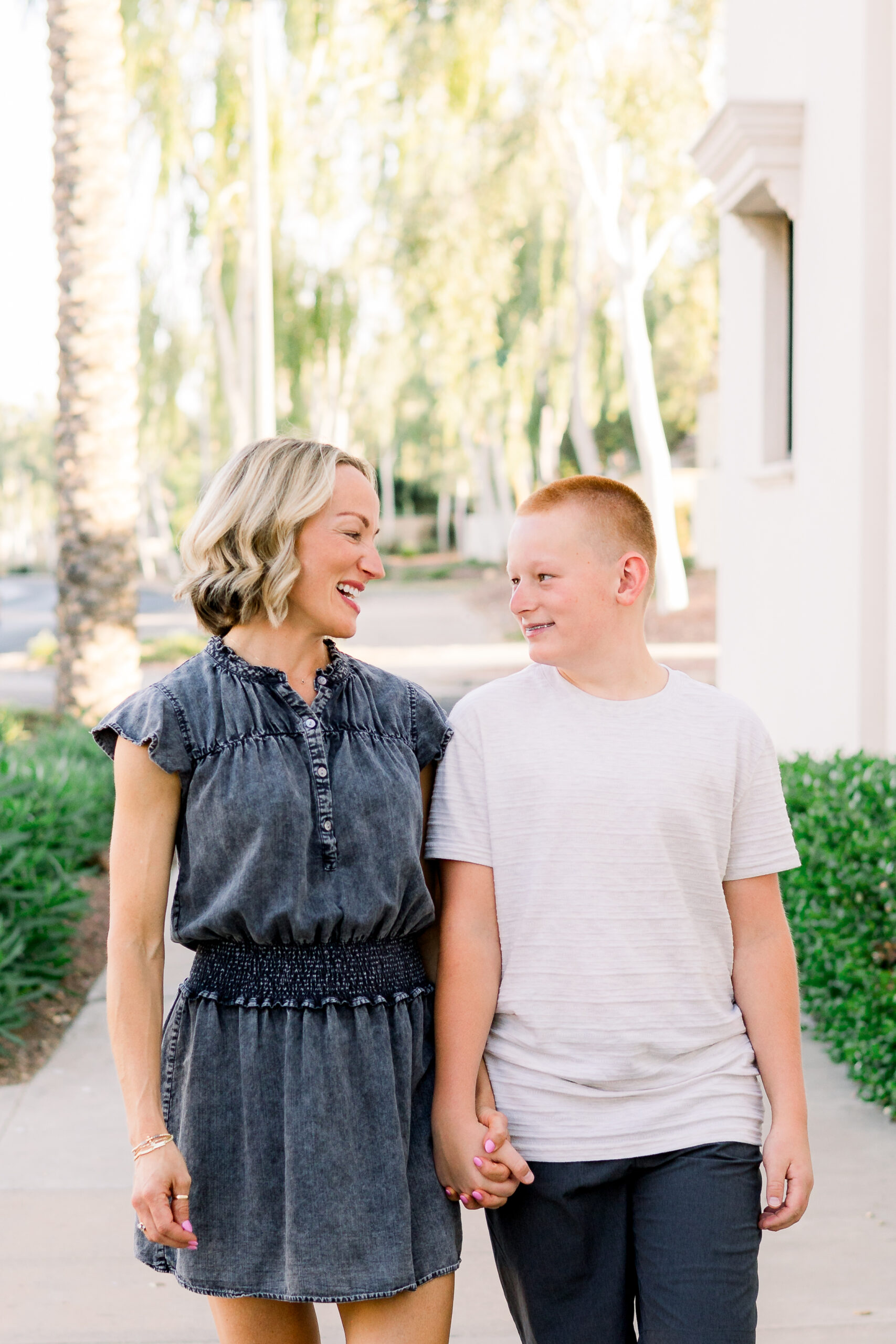 Mom in denim dress walks with son in Verrado, in Buckeye, AZ.