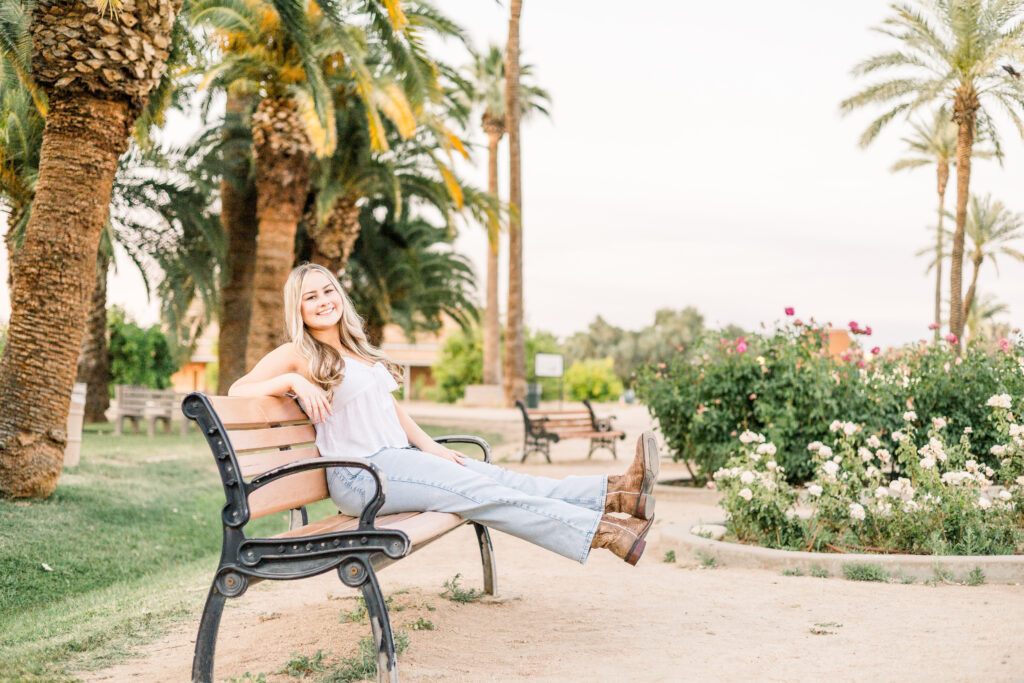 Senior girl on park bench with roses in Glendale, Arizona.