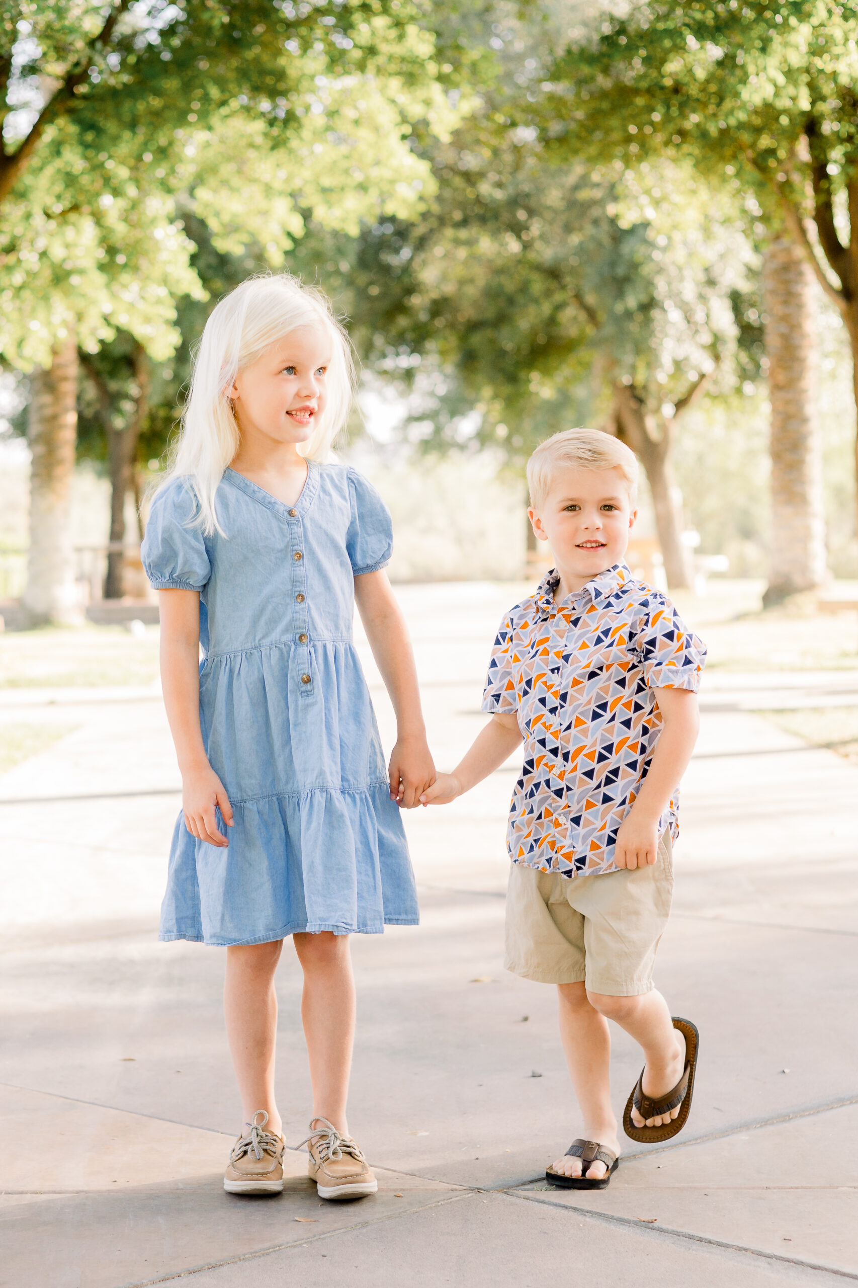 Brother and sister hold hands at park in Peoria, AZ neighborhood of Vistancia.